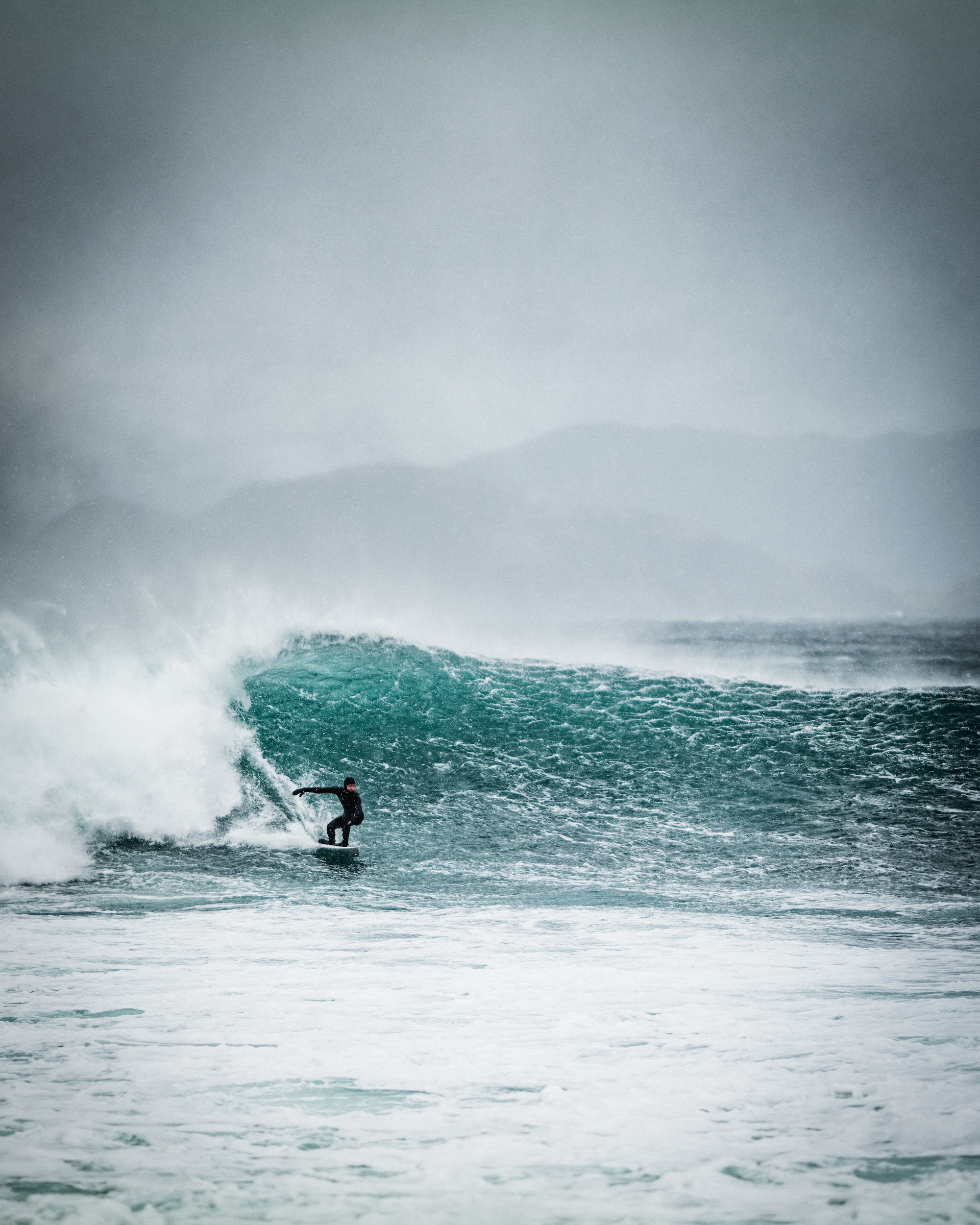 Surfer Emil Aslaksrud surfer på en stor bølge. Foto: Simon Sjøkvist.