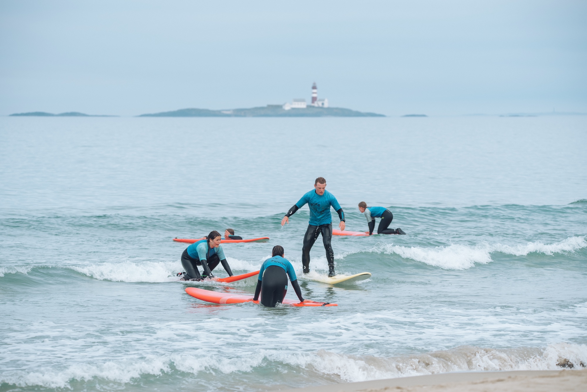 Surfekurs med Boretunet Flere mennesker lærer å surfe på et surfekurs med Boretunet.