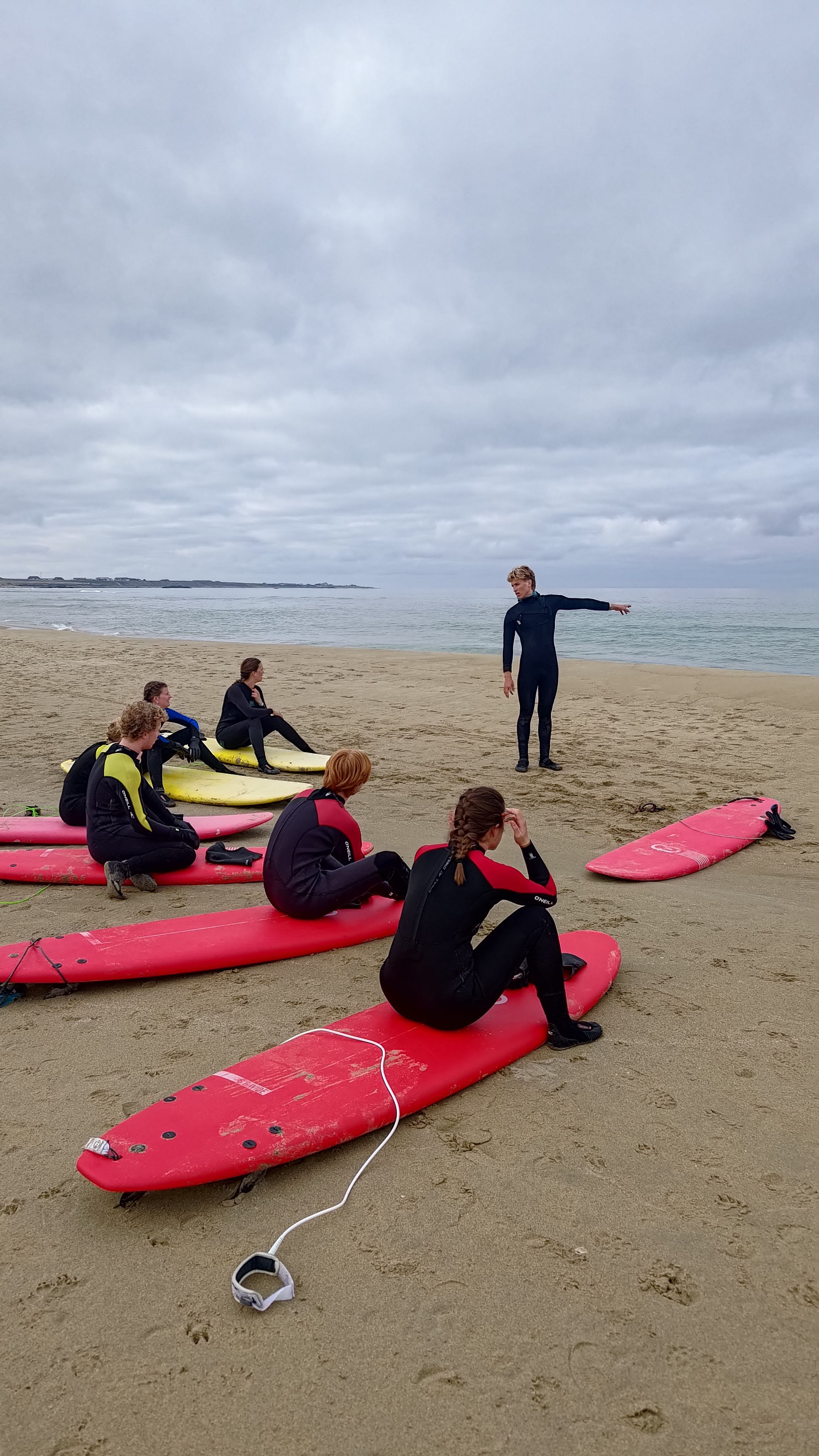 Surf-instruktør fra Boretunet viser en elev hvordan man kommer i gang med surfing.